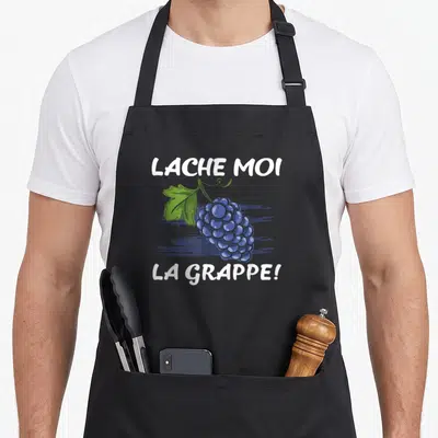 Tablier de cuisine noir avec une illustration de grappe de raisin bleue et le texte Lache moi la grappe en blanc.