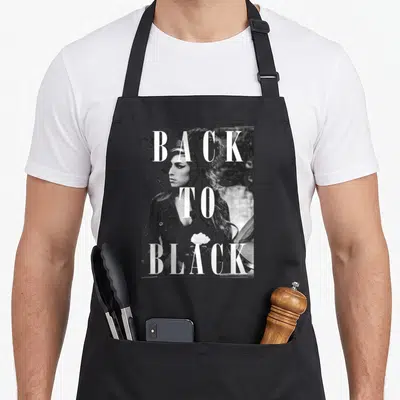 Tablier de cuisine noir avec portrait en noir et blanc d'Amy Winehouse et le texte Back To Black superposé en grandes lettres blanches.