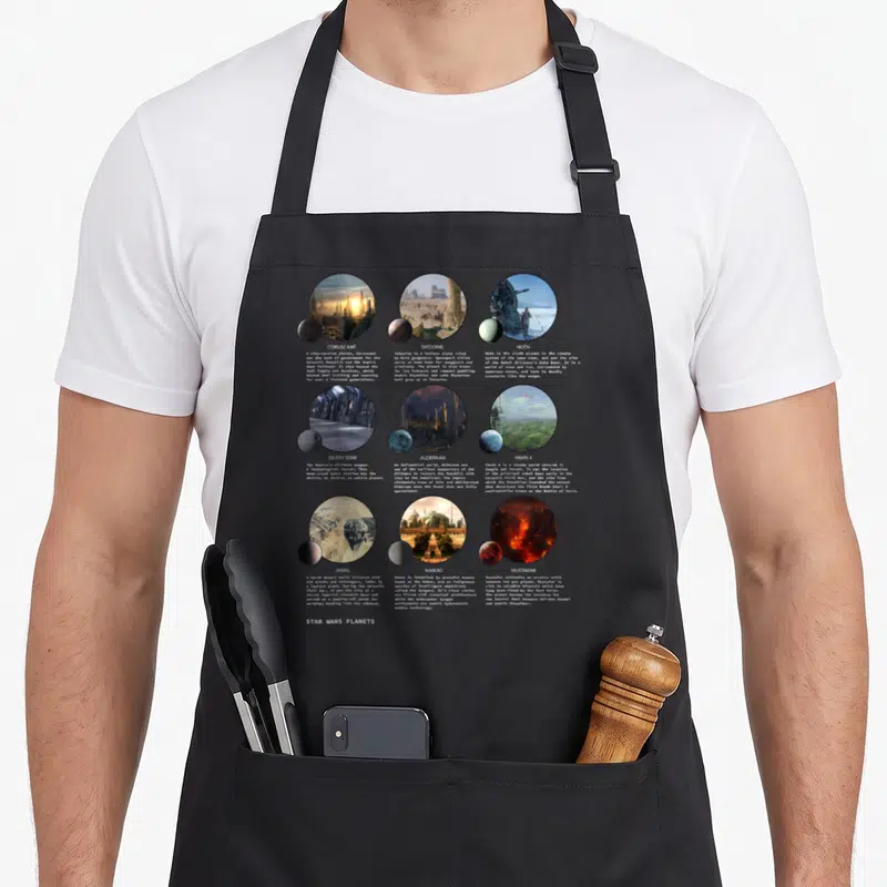 Tablier de cuisine noir avec neuf illustrations circulaires representant des planetes de Star Wars comme Hoth, Naboo et la Death Star.