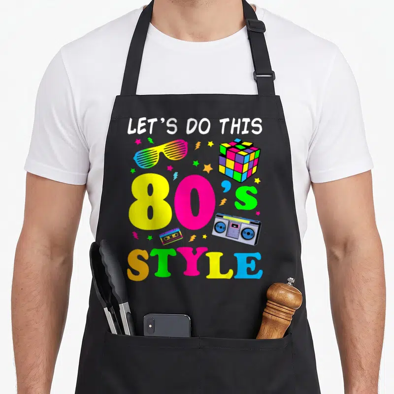 Tablier de cuisine noir avec illustration 80s Style Let's Do This, boombox, cube de Rubik et lunettes à fentes colorées.