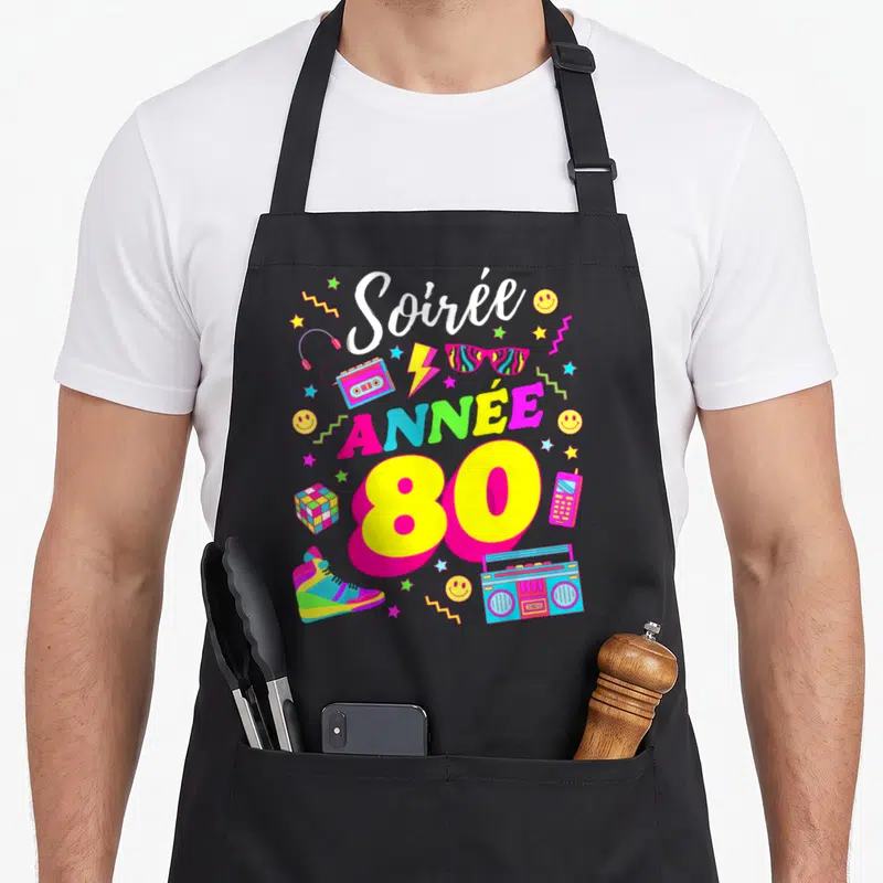Tablier de cuisine noir avec illustration colorée Soirée Année 80, boombox et accessoires rétro sur fond uni.