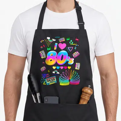 Tablier de cuisine noir avec illustration colorée 80s incluant cassettes, slinky et motifs géométriques rétro.