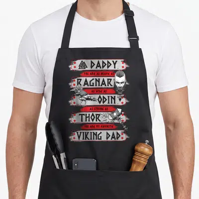 Tablier de cuisine noir avec illustration viking retro incluant Valknut, corbeau, marteau et texte en anglais