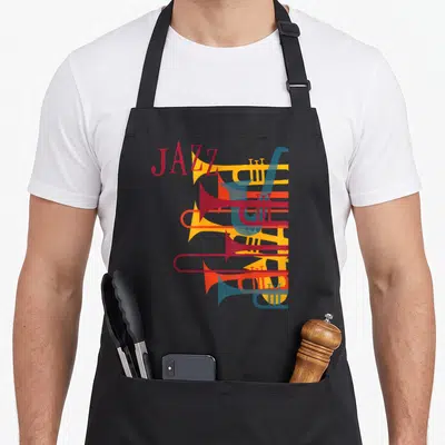Tablier de cuisine noir avec illustration graphique de trompettes superposées aux couleurs vives et le mot Jazz en typographie rétro.