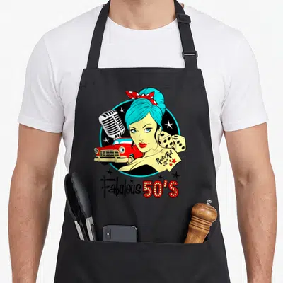 Tablier de cuisine noir avec illustration colorée d'une pinup, voiture rouge et texte Fabulous 50's.
