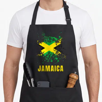 Tablier de cuisine noir avec drapeau Jamaica aquarelle et éclaboussures vertes jaunes noires.