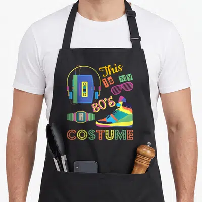 Tablier de cuisine noir avec illustration colorée d'une boombox, d'une montre et du texte This Is My 80s Costume.