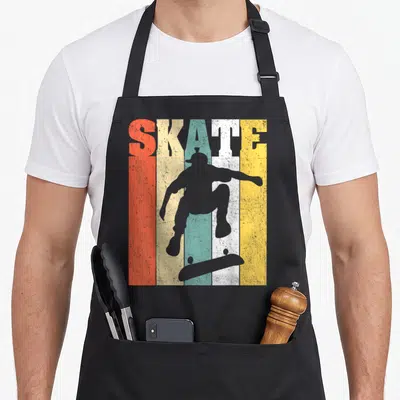 Tablier de cuisine noir avec silhouette de skateur, planche de skateboard et texte Skate sur bandes orange jaune turquoise blanches