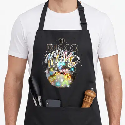 Tablier de cuisine noir avec une boule disco multicolore, une couronne noire et l'inscription Disco King en lettres stylisées.