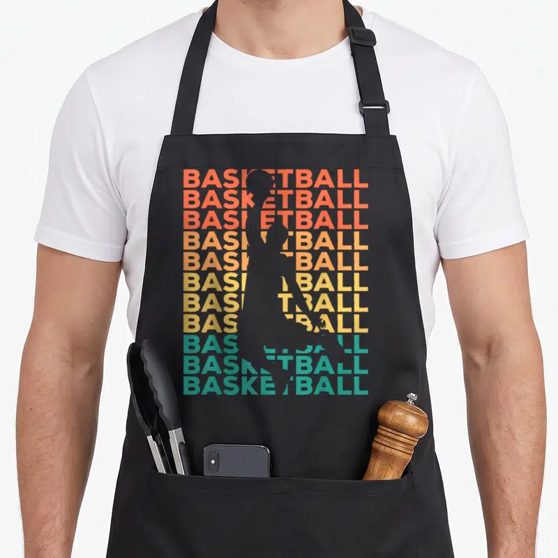 Tablier de cuisine noir avec silhouette de joueur de basket et texte BASKETBALL en dégradé coloré rétro.