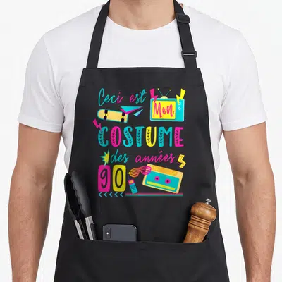 Tablier de cuisine noir avec illustration colorée Mon Costume des années 90 incluant cassette et skateboard.