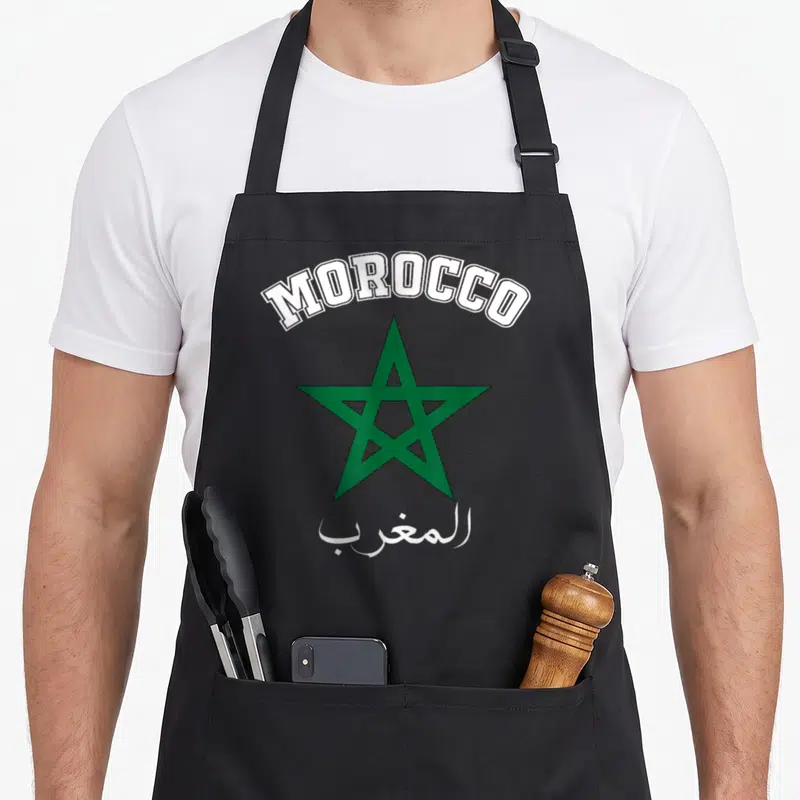 Tablier de cuisine noir avec inscription Morocco, étoile verte et calligraphie arabe blanche.