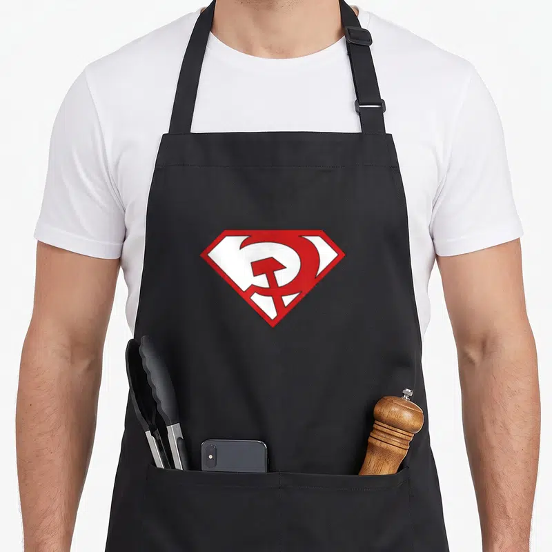 Tablier de cuisine noir avec un logo rouge et blanc inspiré de Superman et du marteau et faucille.