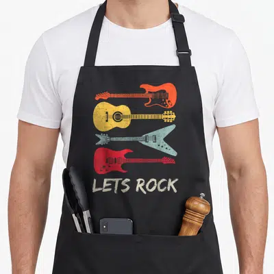 Tablier de cuisine noir avec quatre guitares colorées et le texteLets Rock en bas.