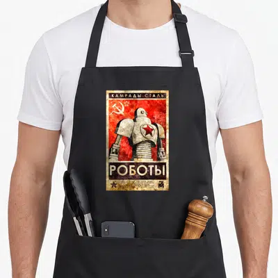 Tablier de cuisine noir avec illustration robotique soviétique, étoile rouge et texte Kamrady Stal Robots en style poster ancien.