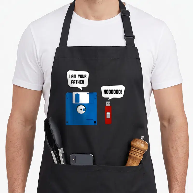 Tablier de cuisine noir avec une disquette bleue et une clé USB rouge en illustration centrale.