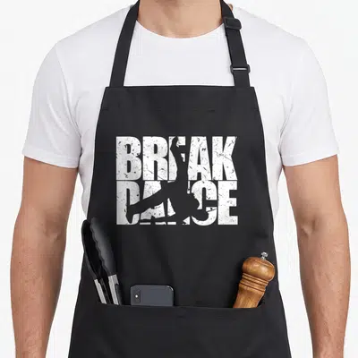Tablier de cuisine noir avec l'inscription BREAK DANCE et la silhouette d'un danseur en mouvement sur fond blanc texturé.