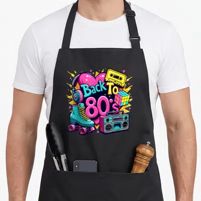 Tablier de cuisine noir avec illustration colorée Back To 80s incluant une cassette, un cube Rubik et des patins.