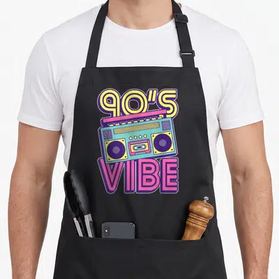 Tablier de cuisine noir avec illustration colorée d'une boombox et du texte 90s Ambiance en lettres stylisées.