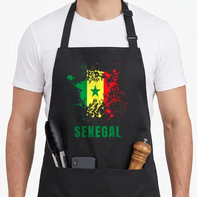 Tablier de cuisine noir avec le drapeau du Sénégal en aquarelle et l'inscription SENEGAL en bas.