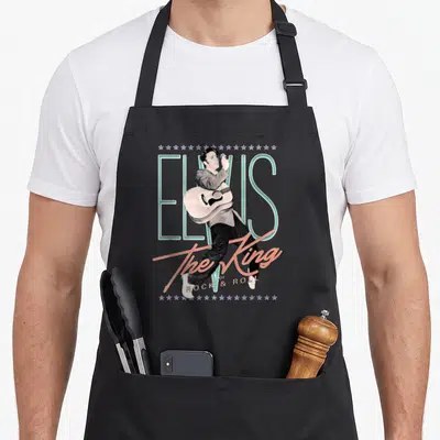 Tablier de cuisine noir avec illustration vintage Elvis Presley jouant de la guitare sous le texte The King.