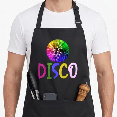 Tablier de cuisine noir avec une boule disco colorée et linscription DISCO en lettres vives.