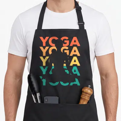 Tablier de cuisine noir avec le mot YOGA répété en dégradé coloré et une silhouette de personne en posture de yoga au centre.