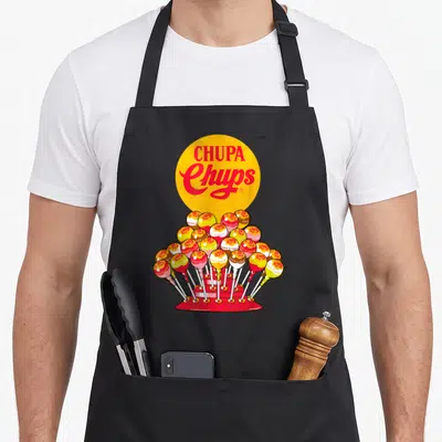Tablier de cuisine noir avec illustration d'un présentoir de bonbons Chupa Chups multicolores sur fond jaune.