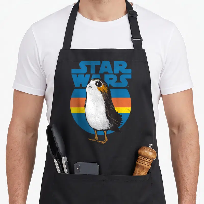 Tablier de cuisine noir avec illustration Porg Star Wars style vintage et logo bleu retro