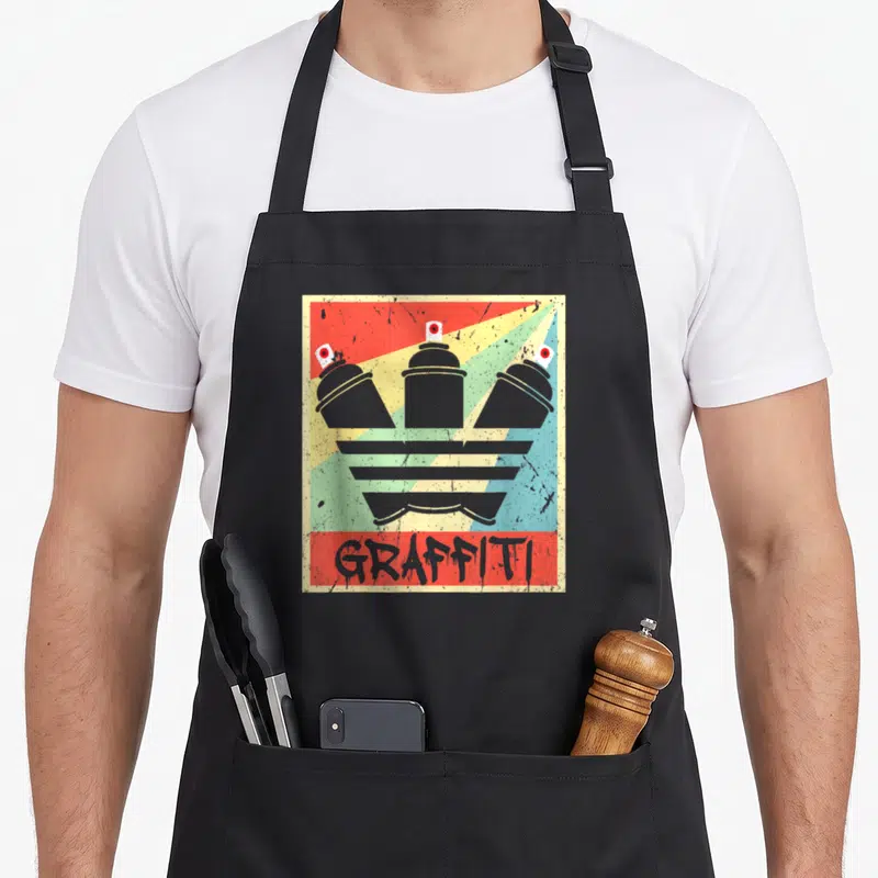 Tablier de cuisine noir avec illustration d'aérosols gris et texte GRAFFITI sur fond rayé coloré