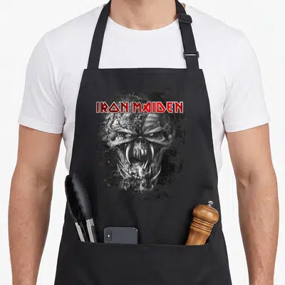 Tablier de cuisine noir avec le logo Iron Maiden rouge et une illustration grise d'Eddie Final Frontier au style vintage.