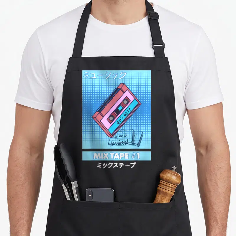 Tablier de cuisine noir avec illustration de cassette rose sur fond quadrillé bleu et texte Mix Tape #1