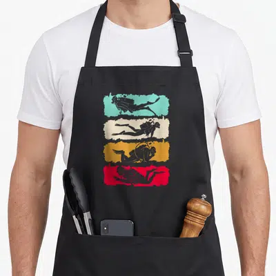 Tablier de cuisine noir avec quatre silhouettes de plongeurs sur bandes turquoise, crème, orange et rouge.