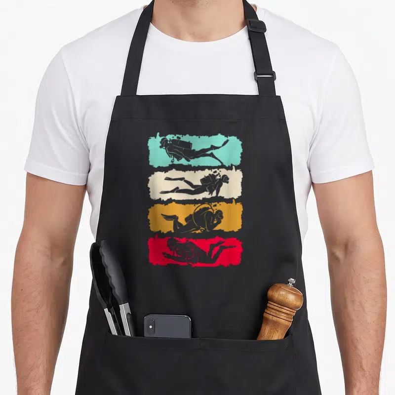 Tablier de cuisine noir avec quatre silhouettes de plongeurs sur bandes turquoise, crème, orange et rouge.