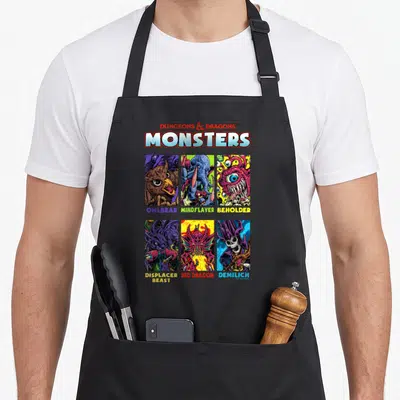 Tablier de cuisine noir avec six illustrations colorées de monstres fantastiques style rétro.