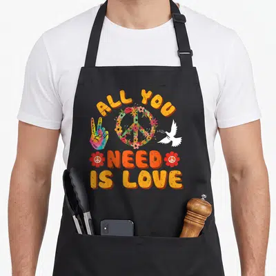 Tablier de cuisine noir avec inscription All You Need is Love, main tie dye et colombe blanche.