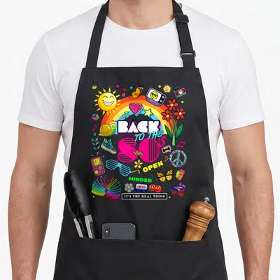 Tablier de cuisine noir avec illustration colorée Back to the 80's incluant un arc-en-ciel, des lunettes shutter et une cassette audio.