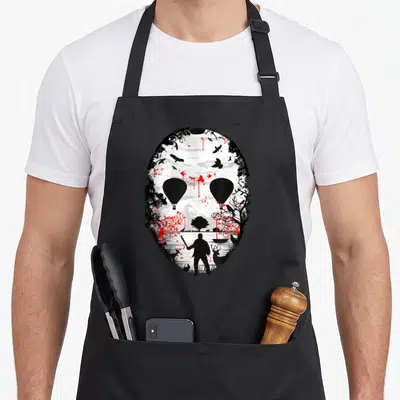 Tablier de cuisine noir avec illustration d'un masque de hockey contenant une scène de forêt et une silhouette armée.