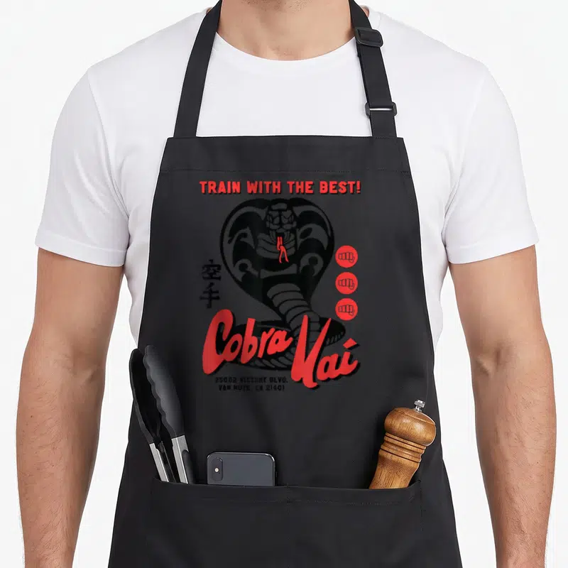 Tablier de cuisine noir avec illustration cobra rouge et texte Train with the Best Cobra Kai