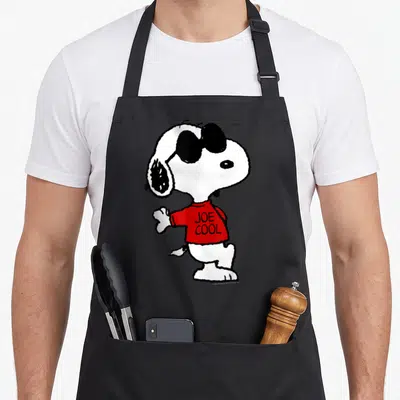 Tablier de cuisine noir avec Snoopy Joe Cool en pull rouge et lunettes noires.