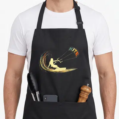 Tablier de cuisine noir avec illustration vintage d'un kitesurfeur sur une vague et un cerf-volant portant l'inscription KITE.