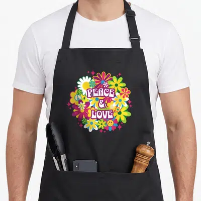 Tablier de cuisine noir avec un motif circulaire Peace & Love floral rétro 70s coloré et joyeux.