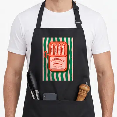 Tablier de cuisine noir avec illustration rétro d'une boîte de sardines ouverte sur fond de bandes vertes et roses ondulées.