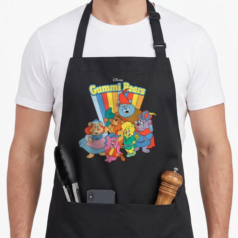 Tablier de cuisine noir avec illustration colorée des Gummi Bears et leur logoDisney au-dessus.