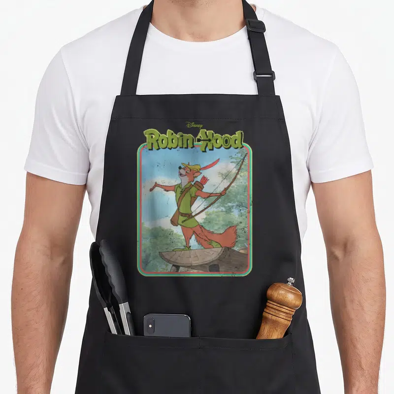 Tablier de cuisine noir avec illustration rétro de Robin Hood fox tenant un arc sur une souche d'arbre sous le logo Disney.