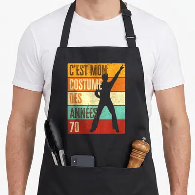 Tablier de cuisine noir avec silhouette disco et texte C'est mon costume des années 70 sur bandes colorées.