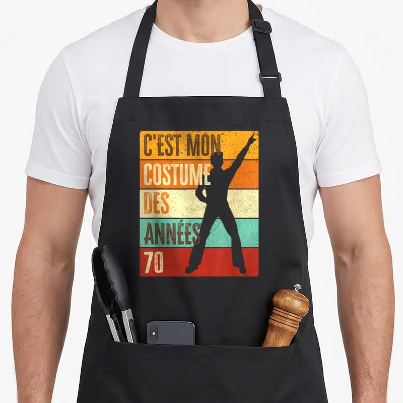 Tablier de cuisine noir avec silhouette disco et texte C'est mon costume des années 70 sur bandes colorées.
