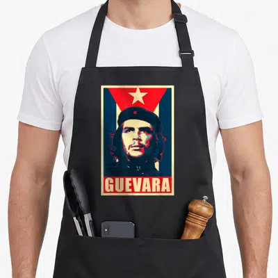 Tablier de cuisine noir avec illustration rétro de Guevara, étoile rouge et texte en bas.
