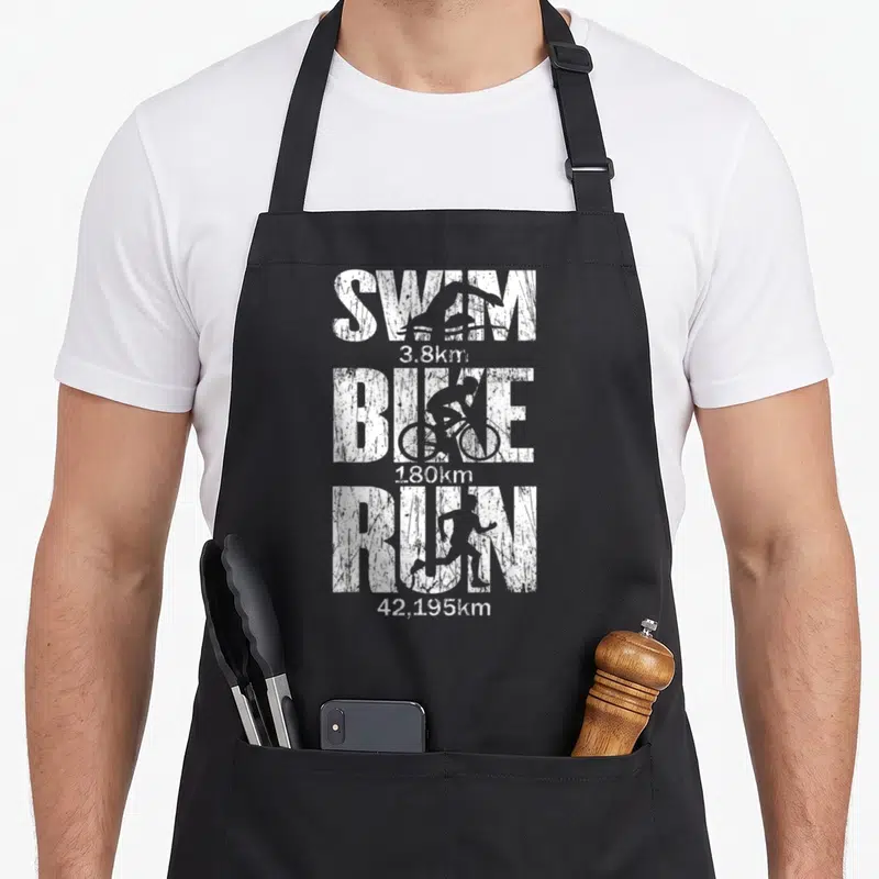 Tablier de cuisine noir avec inscription blanche SWIM BIKE RUN et silhouettes de sportifs en style vintage délavé.