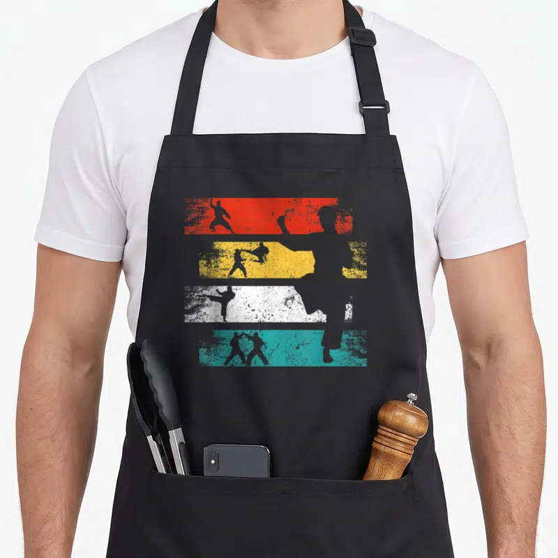 Tablier de cuisine noir avec silhouettes de combattants sur bandes rouges jaunes blanches et bleues style rétro délavé